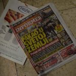 a pile of newspapers sitting on top of a tiled floor