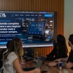 Three colleagues viewing a business presentation on a large screen.